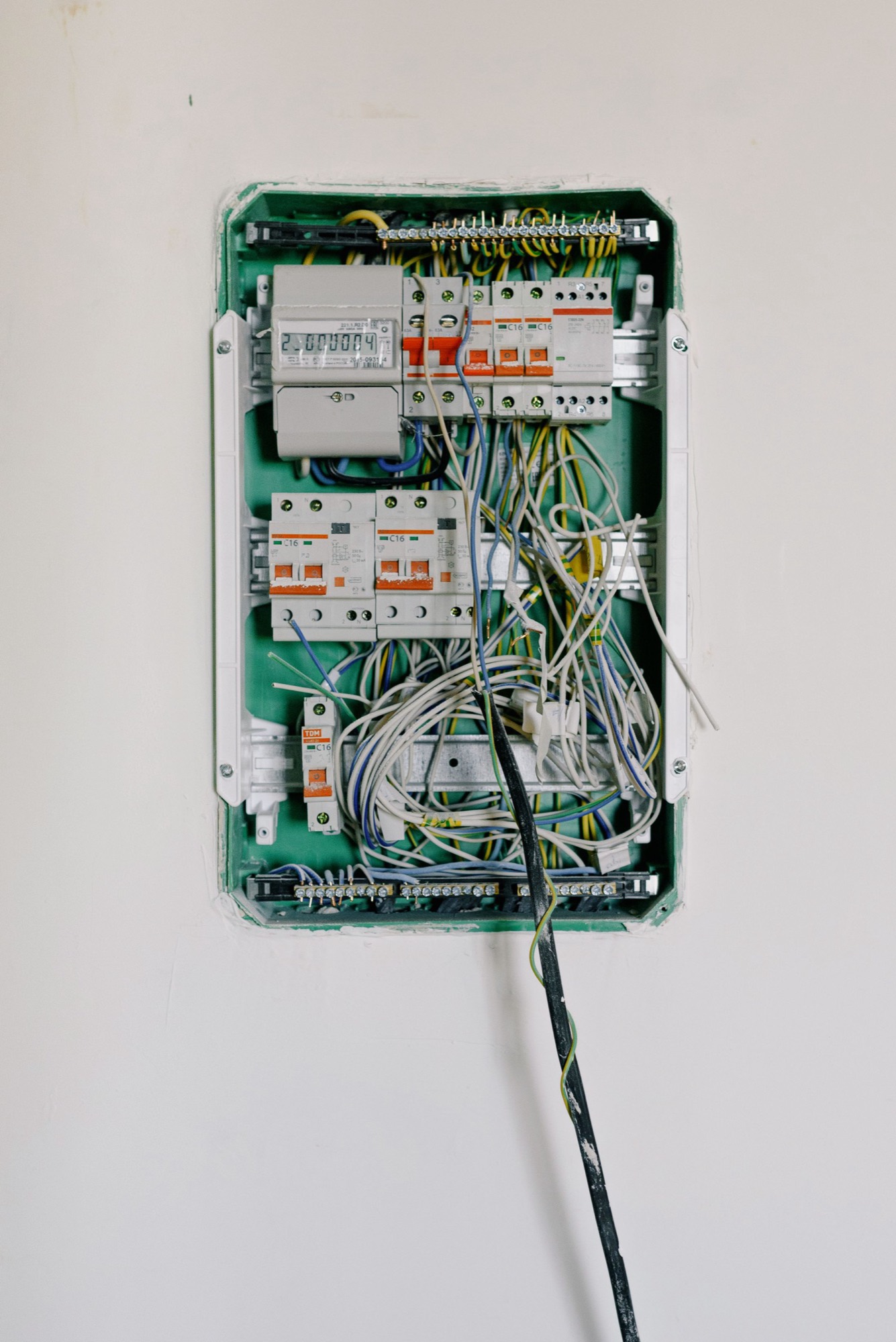 A consumer unit opened up, with circuit breakers and cabling terminated into the bars